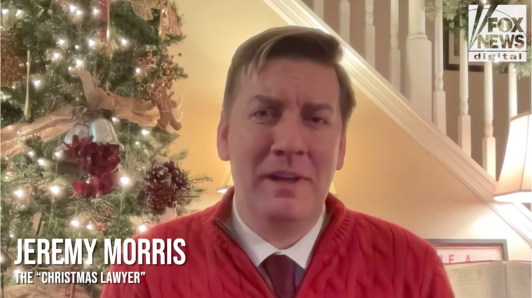 Jeremy Morris, known as the Christmas Lawyer, speaks on camera in front of a decorated Christmas tree, wearing a red sweater inside a warmly lit home, with a Fox News Digital logo visible. Caption: